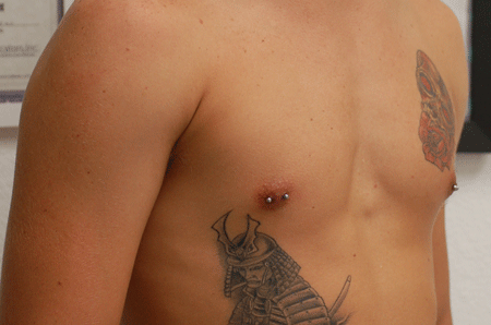 The nipple piercings look great with his tattoos